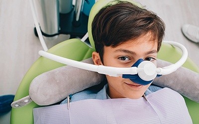 A young boy sitting in the dentist’s chair preparing to receive nitrous oxide