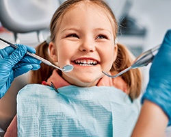 Closeup of child with pigtails smiling during dental checkup