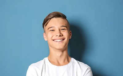 Teenager smiling after visiting pediatric dentist in Birmingham
