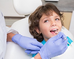 A little boy has his teeth examined before receiving nitrous oxide