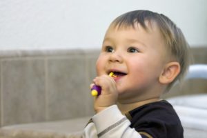 A child brushing their teeth in preparation for their dental visit.