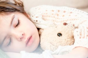 Sleeping child holding stuffed animal
